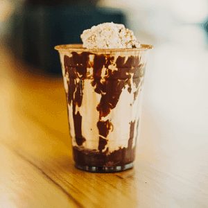 A rich chocolate float topped with a scoop of creamy gelato in a tall glass.