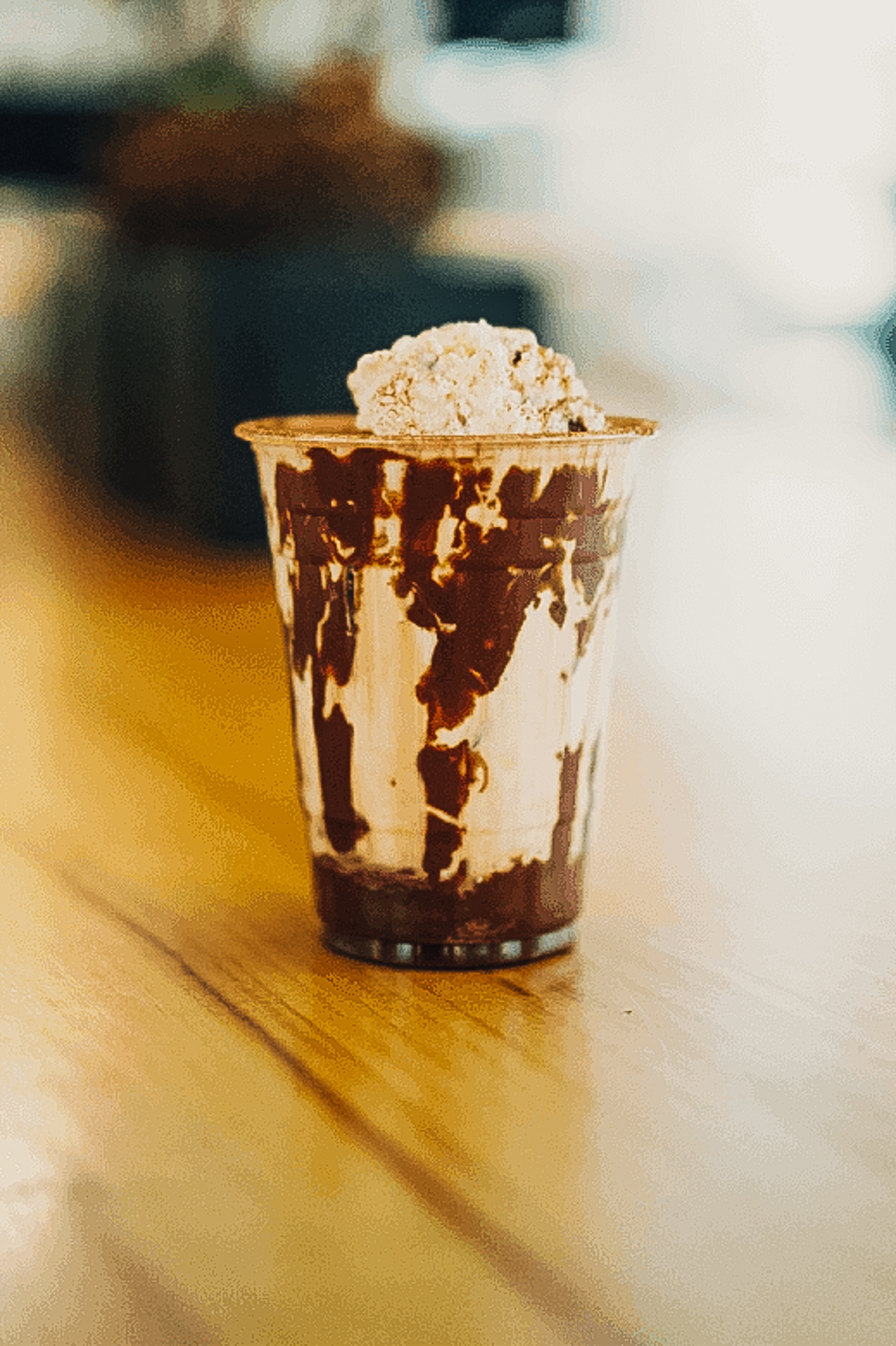 A rich chocolate float topped with a scoop of creamy gelato in a tall glass.