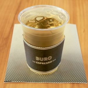 A refreshing glass of iced Sencha green tea with a golden-green hue and delicate floral notes.