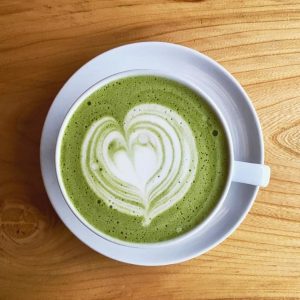 A vibrant matcha latte, with a smooth blend of creamy milk and bright green matcha powder.