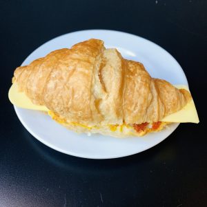 A warm Vegan Cheese Croissant with a swirl of sundried tomato pesto, offering a perfect blend of buttery layers and tangy, dairy-free cheese.